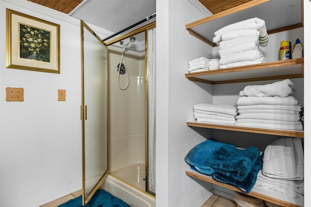 bathroom with tile patterned flooring, an enclosed shower, wood ceiling, and crown molding