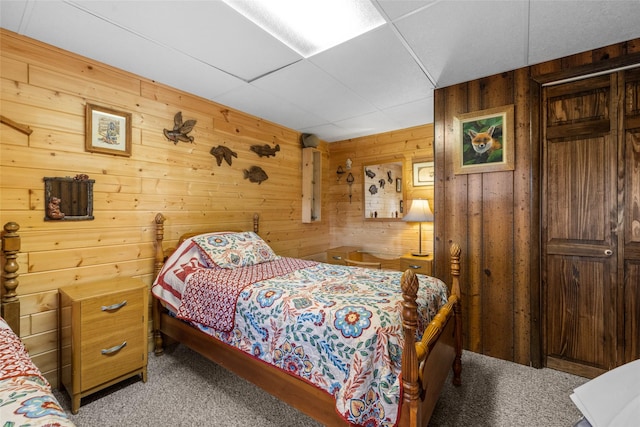 bedroom with carpet flooring and wooden walls