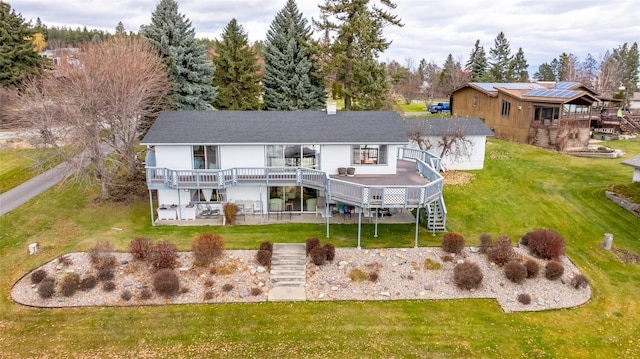 back of property with a lawn, a wooden deck, and a patio