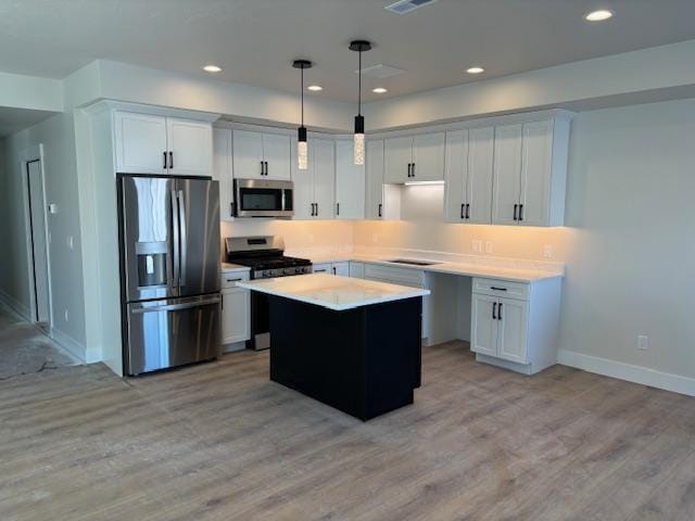 kitchen featuring hanging light fixtures, a kitchen island, white cabinets, and appliances with stainless steel finishes