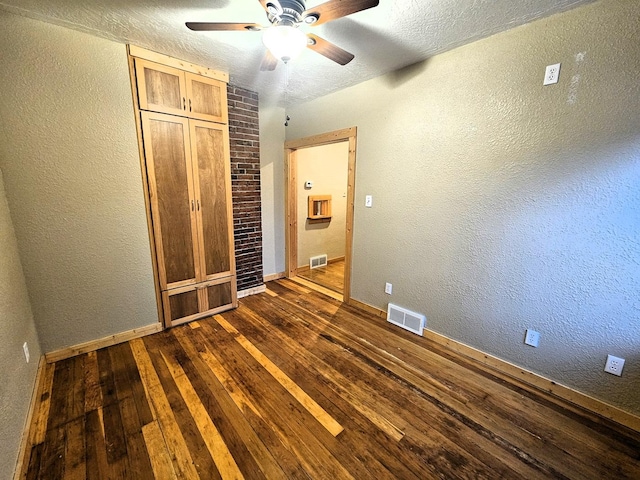 1733 S 11th St W, Missoula, MT 59801 - unfurnished bedroom with dark wood-style floors, a textured wall, baseboards, a textured ceiling, and a ceiling fan
