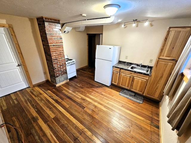 kitchen with a textured ceiling, dark hardwood / wood-style flooring, white appliances, and sink