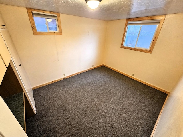 carpeted spare room featuring a textured ceiling