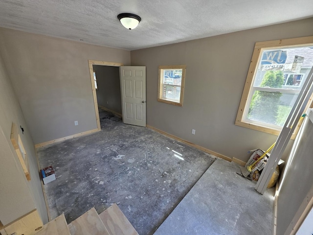 1733 S 11th St W, Missoula, MT 59801 - unfurnished bedroom with multiple windows, baseboards, and a textured ceiling