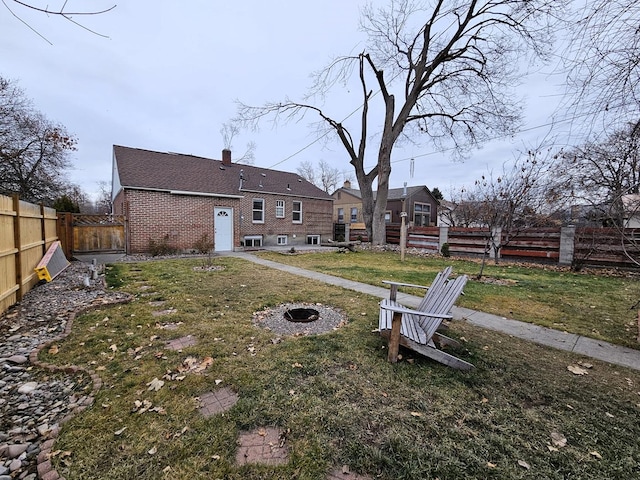 1733 S 11th St W, Missoula, MT 59801 - rear view of property with brick siding, a chimney, a fire pit, and a shingled roof