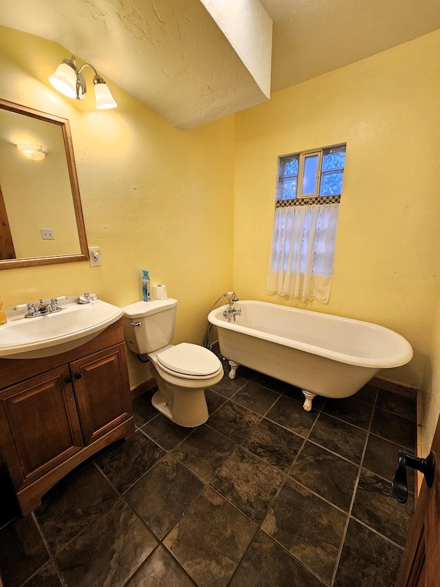 bathroom featuring vanity, toilet, and a tub