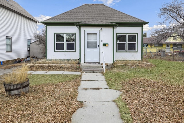 bungalow-style home featuring a front lawn