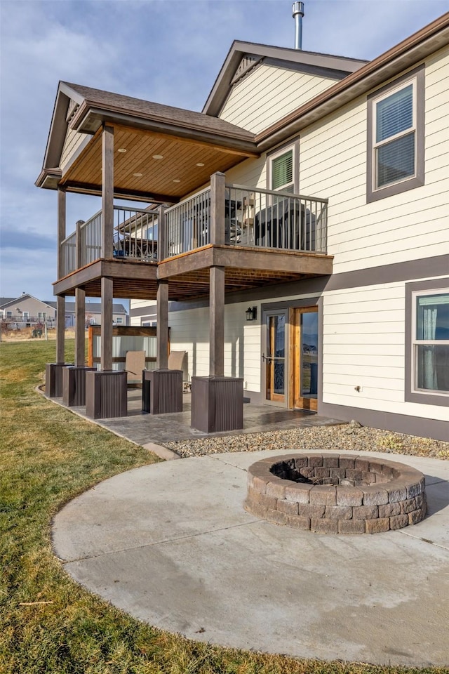 rear view of house with an outdoor living space with a fire pit, a patio area, and a wooden deck