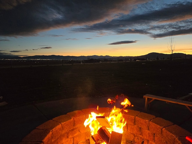 patio terrace at dusk with a mountain view and a fire pit