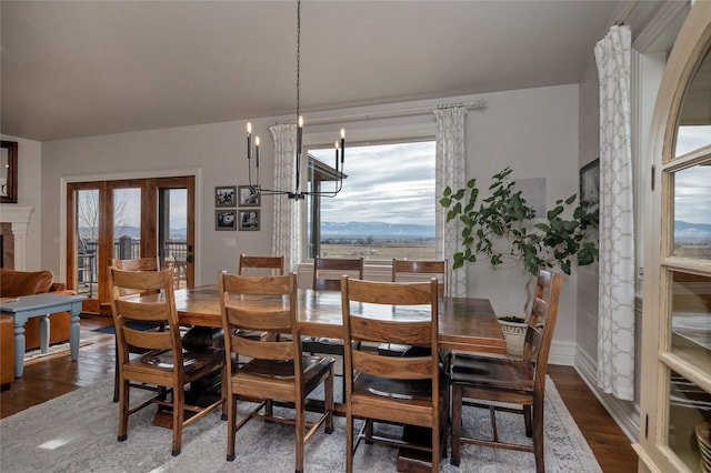 dining area with a mountain view, dark hardwood / wood-style flooring, and an inviting chandelier