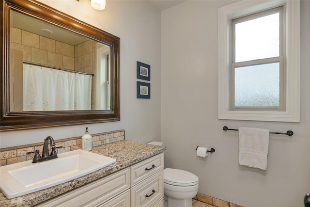 bathroom with vanity, curtained shower, and toilet