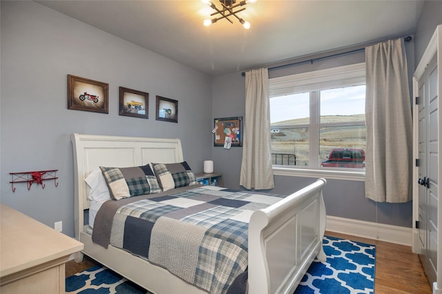 bedroom featuring hardwood / wood-style floors and an inviting chandelier