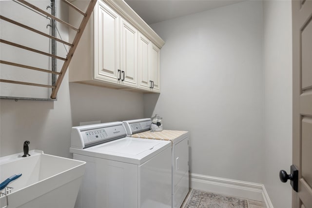 washroom with cabinets, sink, and washer and dryer