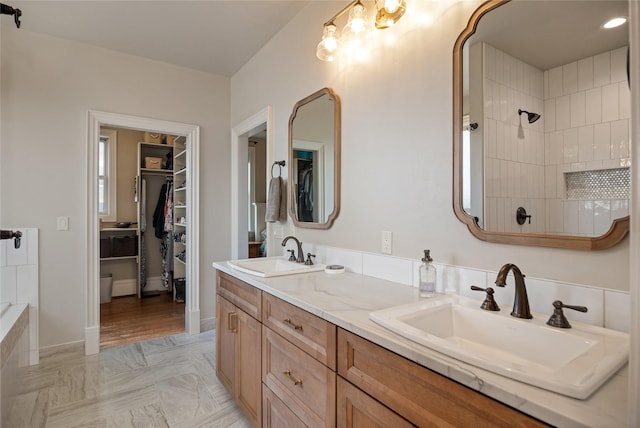 bathroom with a tile shower, vanity, and wood-type flooring