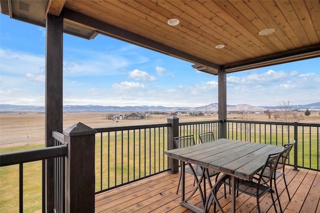 deck featuring a mountain view, a yard, and a rural view