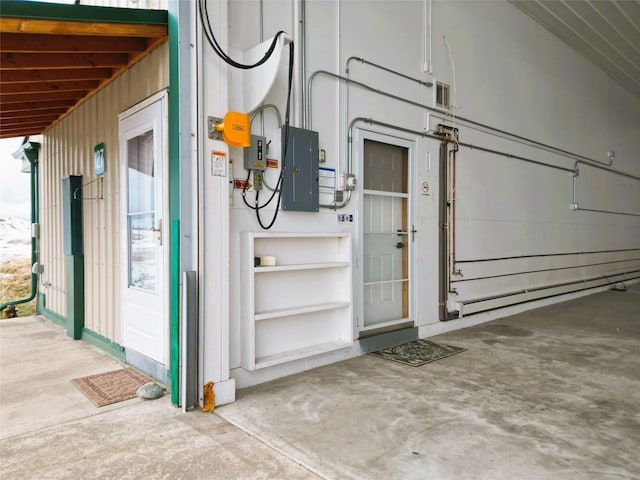 garage featuring electric panel and a baseboard heating unit