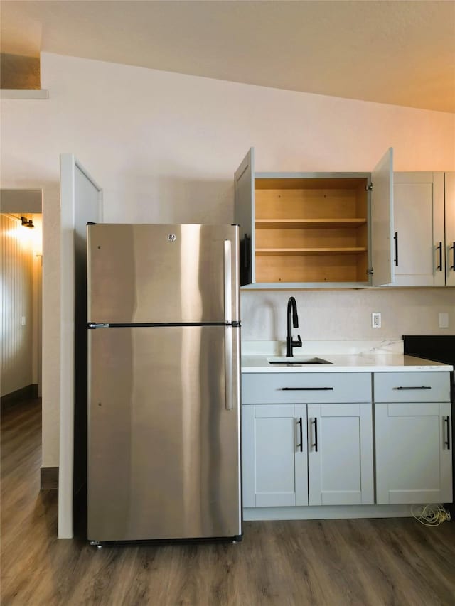 kitchen with stainless steel fridge, dark hardwood / wood-style floors, vaulted ceiling, and sink