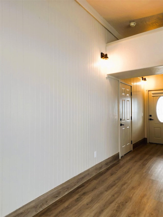 interior space featuring beam ceiling, wood walls, and wood-type flooring