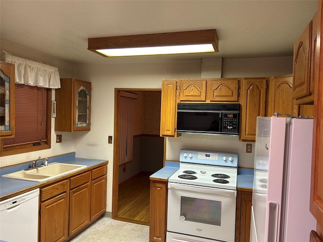 kitchen featuring white appliances, sink, and light hardwood / wood-style flooring