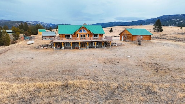 back of house with a mountain view, an outbuilding, and a rural view