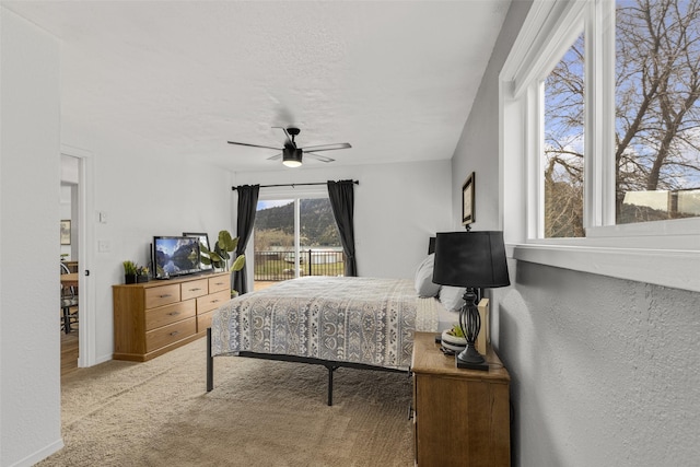 carpeted bedroom featuring access to exterior and ceiling fan