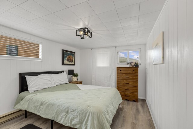 bedroom with a baseboard radiator and hardwood / wood-style flooring