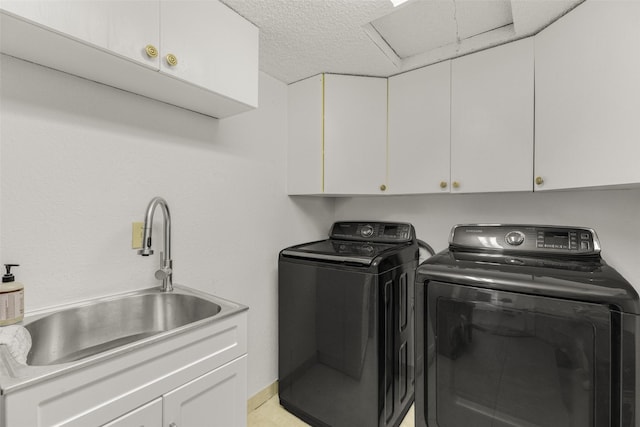 laundry area with washer and dryer, sink, cabinets, and a textured ceiling