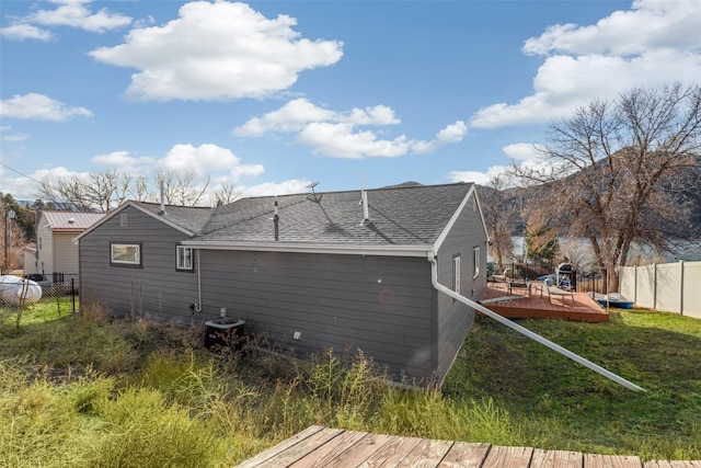 rear view of property with a yard, central AC unit, and a wooden deck