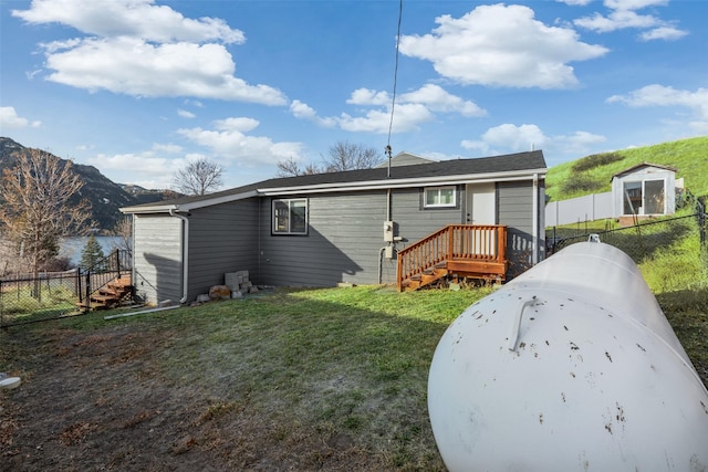 rear view of property with a mountain view and a yard