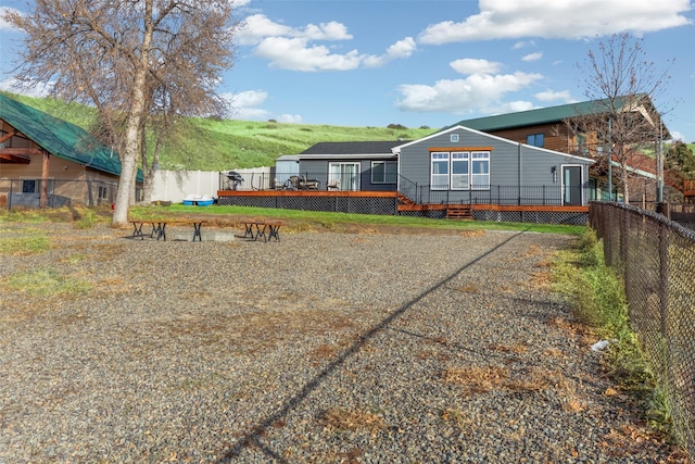 rear view of property featuring a wooden deck