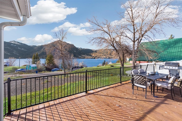 wooden terrace featuring area for grilling and a water and mountain view