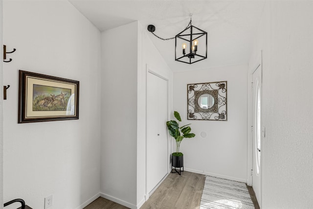 hall featuring light hardwood / wood-style floors and a notable chandelier