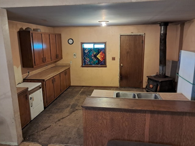 kitchen with white refrigerator, a wood stove, and sink