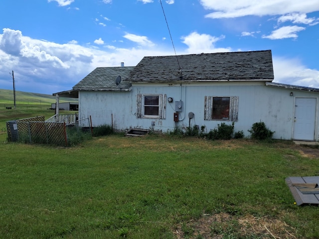 rear view of house featuring a yard