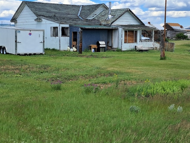 rear view of property featuring a yard