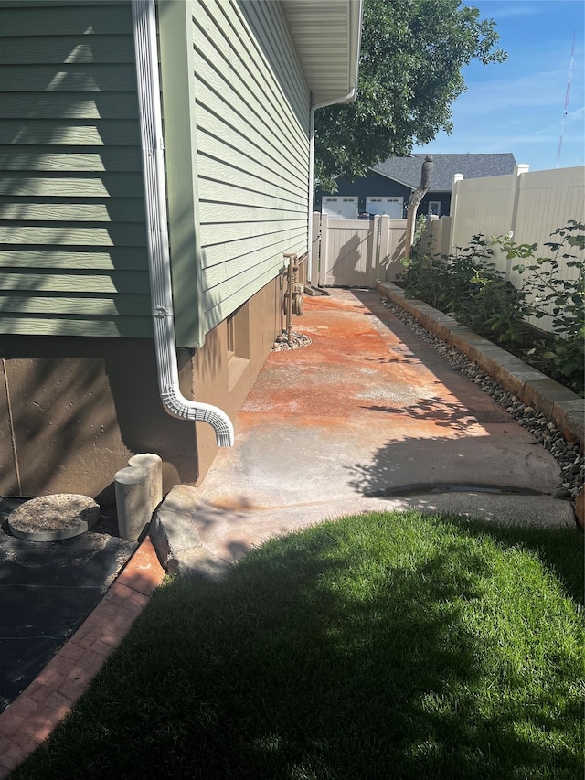 view of side of home with crawl space, a patio area, and fence