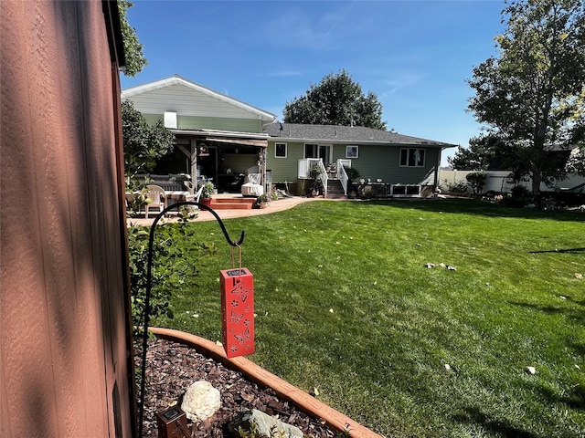 rear view of property featuring a lawn and a patio