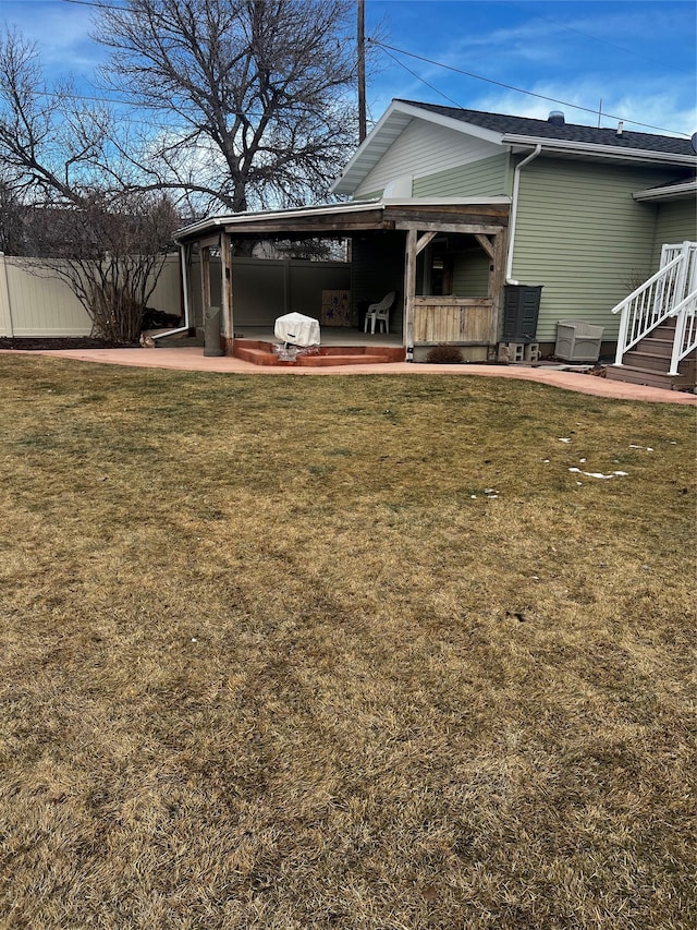 rear view of house with a patio, fence, and a lawn