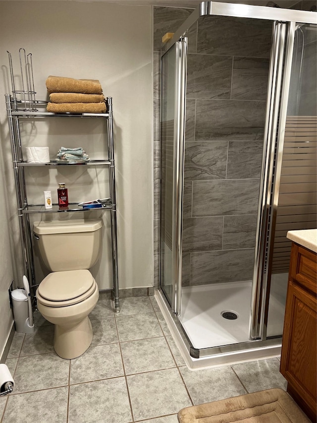 bathroom featuring toilet, a stall shower, and tile patterned floors