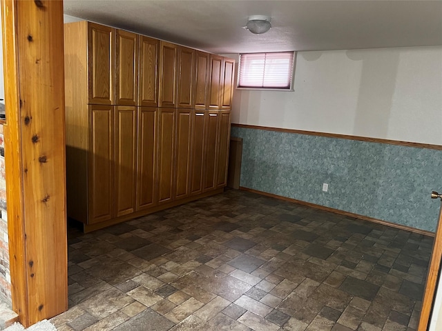 interior space featuring baseboards and wallpapered walls