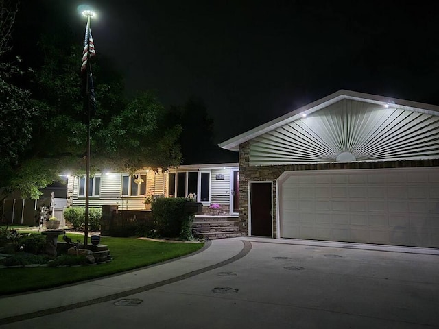 ranch-style home featuring a garage, stone siding, and driveway