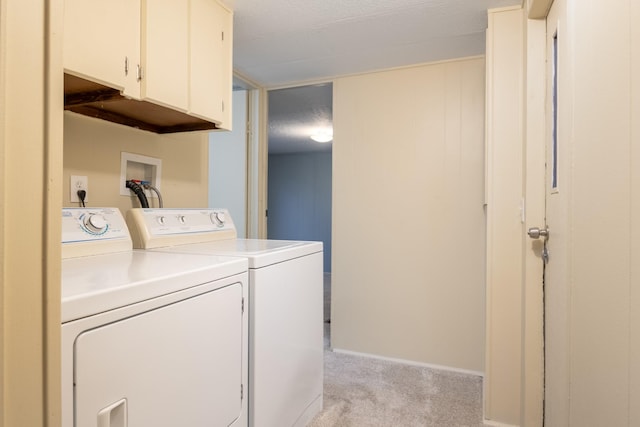 laundry room featuring cabinets, light colored carpet, separate washer and dryer, and a textured ceiling