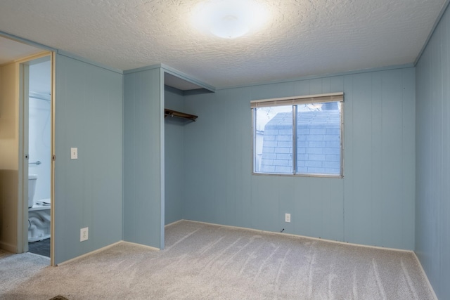 spare room featuring carpet flooring and a textured ceiling