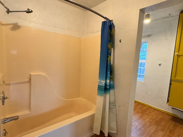 bathroom with hardwood / wood-style floors and shower / bathtub combination with curtain