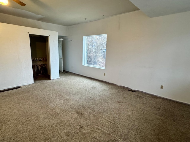 carpeted empty room featuring ceiling fan