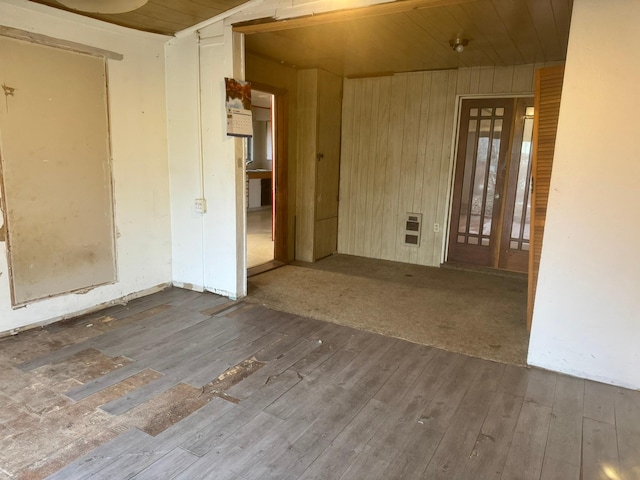 unfurnished room with hardwood / wood-style flooring, wood walls, and wooden ceiling