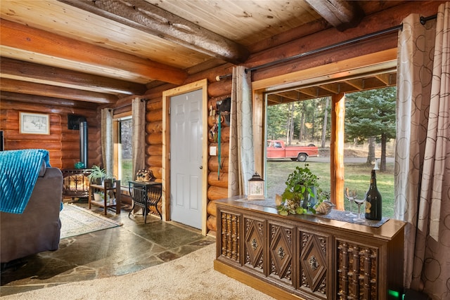 sunroom / solarium with beamed ceiling, plenty of natural light, and a wood stove