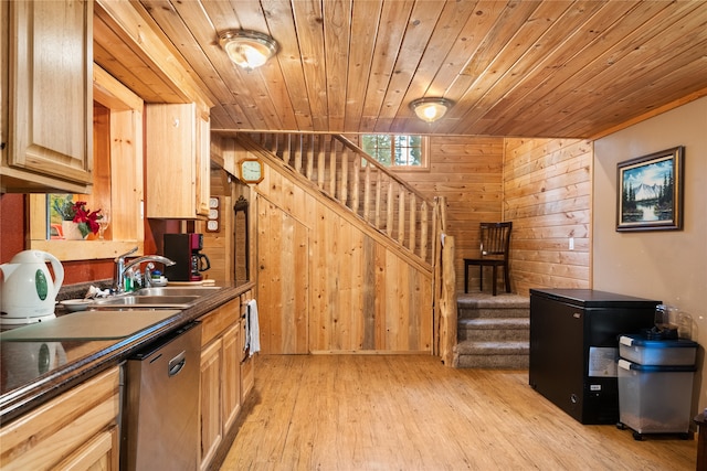 kitchen with sink, light brown cabinets, light hardwood / wood-style flooring, dishwasher, and wood walls