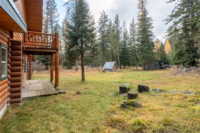 view of yard featuring a deck and a storage shed