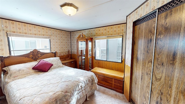 bedroom with ornamental molding, light carpet, and wallpapered walls